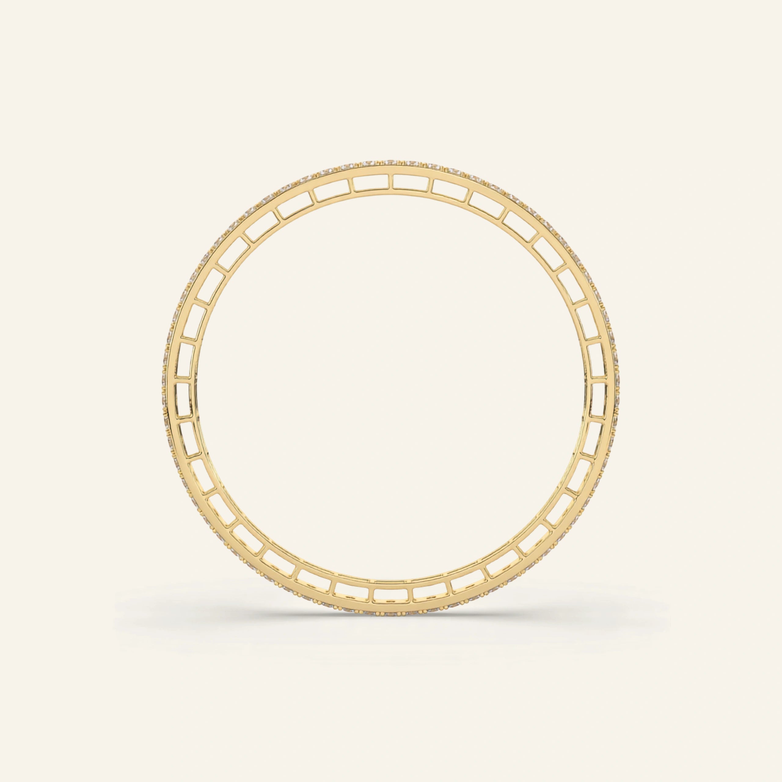 A yellow gold bangle bracelet with a repeating rectangular cutout pattern, shown on a clean off-white background.